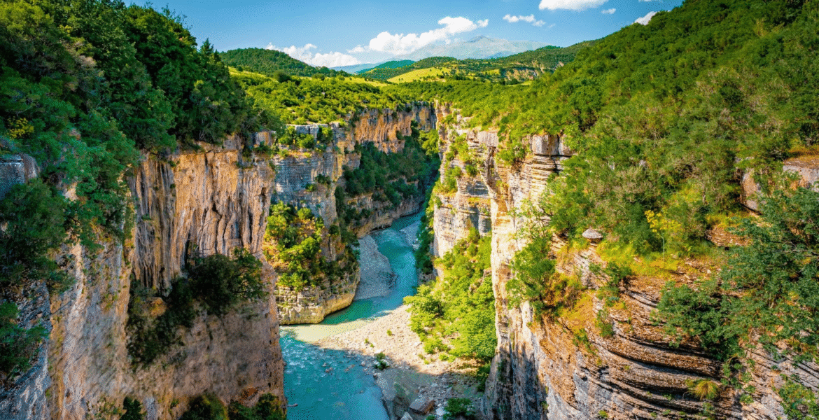 http://Aerial%20view%20of%20the%20Osumi%20Canyon%20in%20Albania%20with%20towering%20limestone%20cliffs%20and%20the%20winding%20turquoise%20Osum%20River.